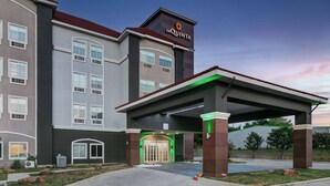 A hotel with a modern facade, a covered entrance, and a sign reading "La Quinta".