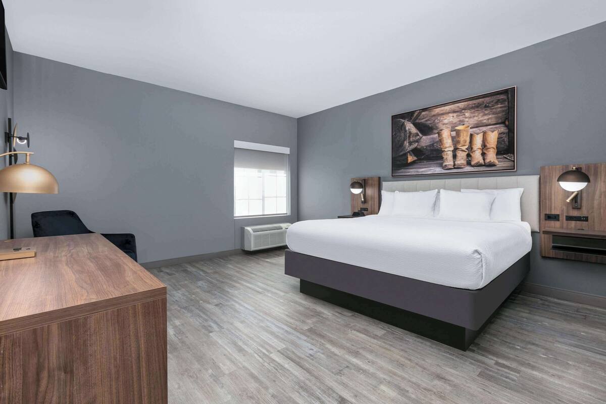 Une chambre d’hôtel moderne avec un grand lit, un bureau et une fenêtre.