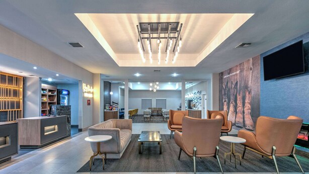 A modern lobby with a reception desk, seating area, and a large wall mural.