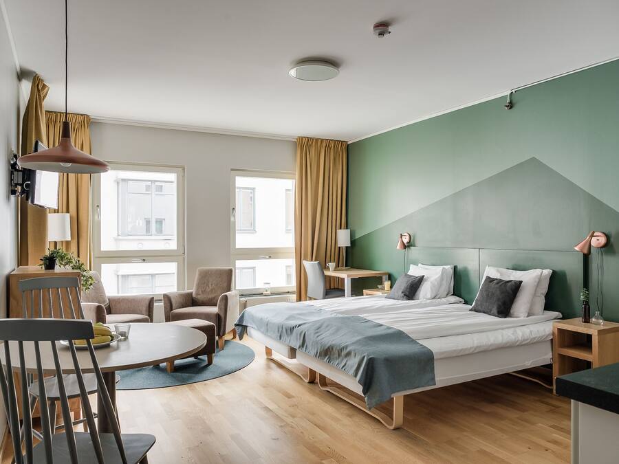 Une chambre d’hôtel moderne équipée d’un lit, d’un bureau, d’une chaise et d’une table à manger.