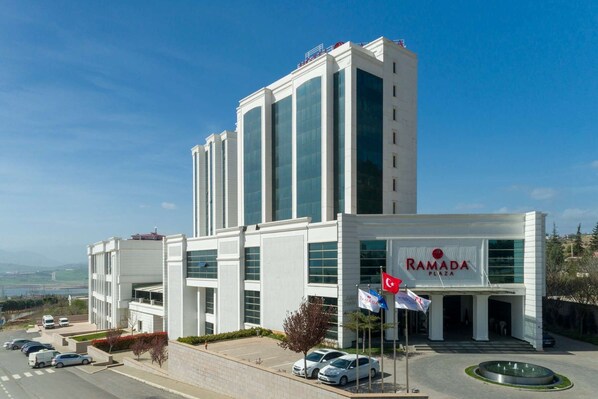Un edificio moderno con un letrero grande que dice "RAMADA PLAZA".