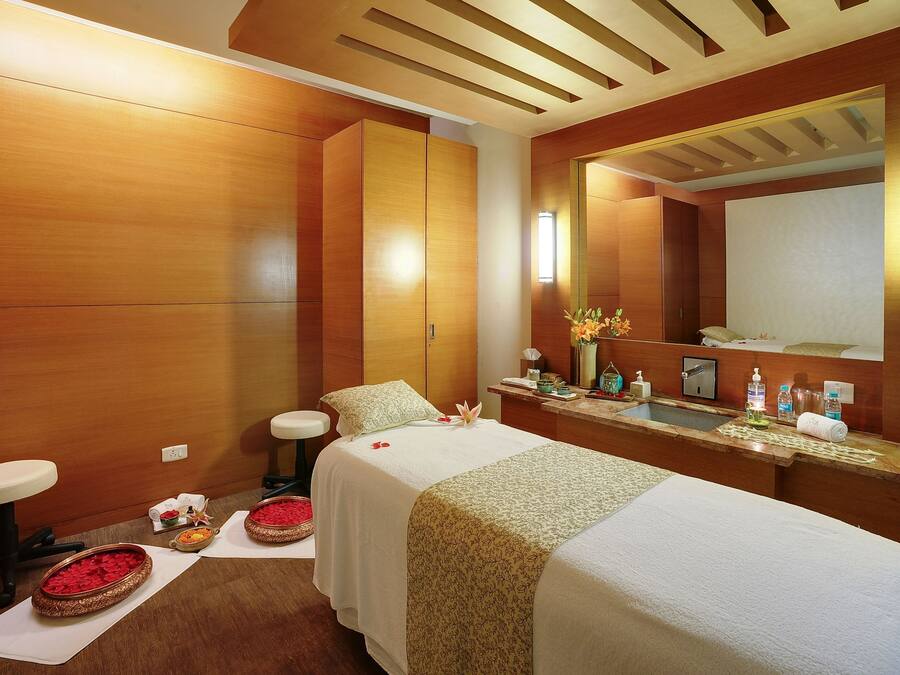Ein modernes Badezimmer mit Holzwänden, einem großen Spiegel, einem Waschbecken und einem Bett mit weißer Bettdecke.