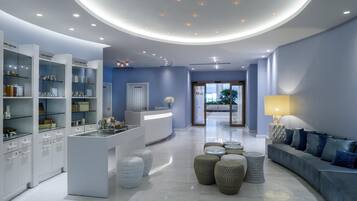 A modern lobby with a reception desk, seating area, and display shelves.