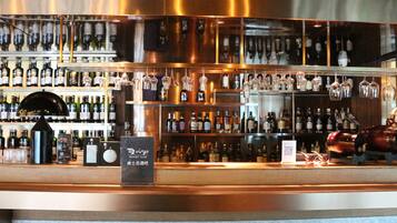 A bar area with shelves of liquor bottles, a whiskey display, and hanging glassware.