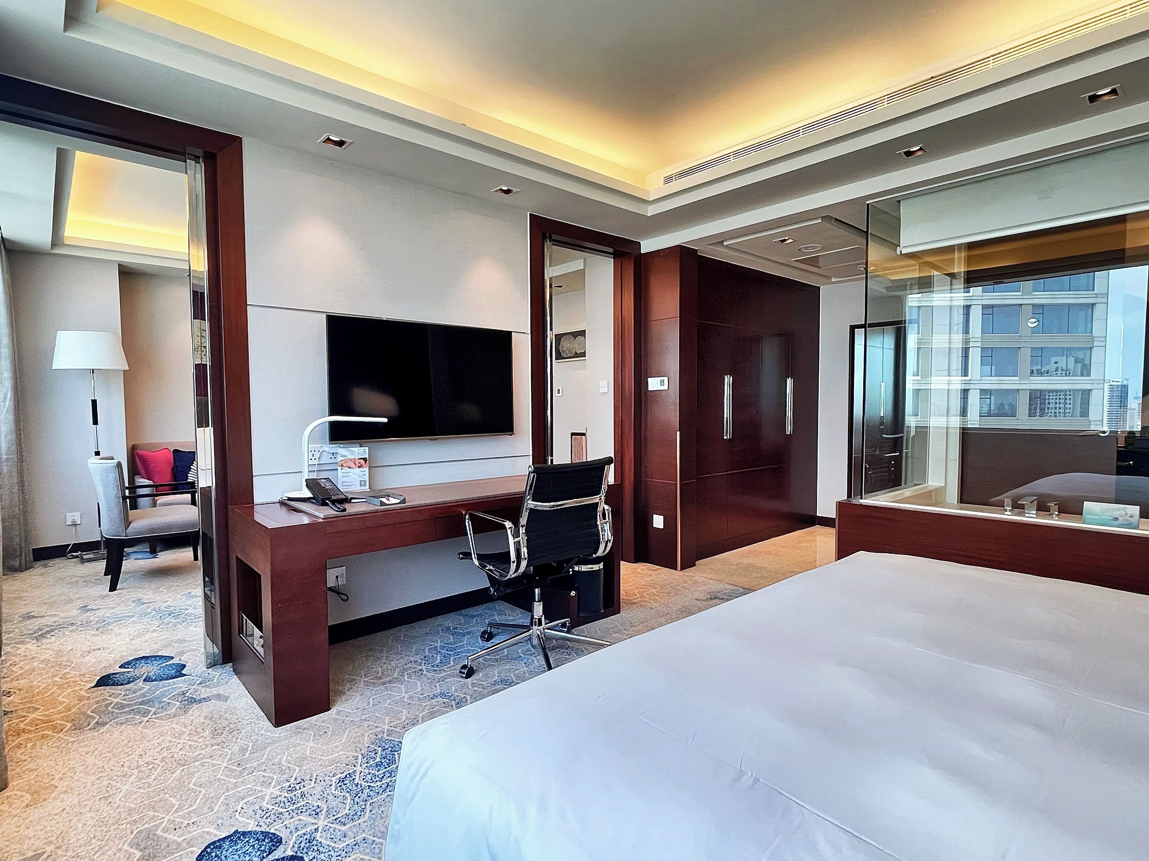 Una habitación de hotel con una cama grande, un escritorio con computadora, un televisor y un armario.
