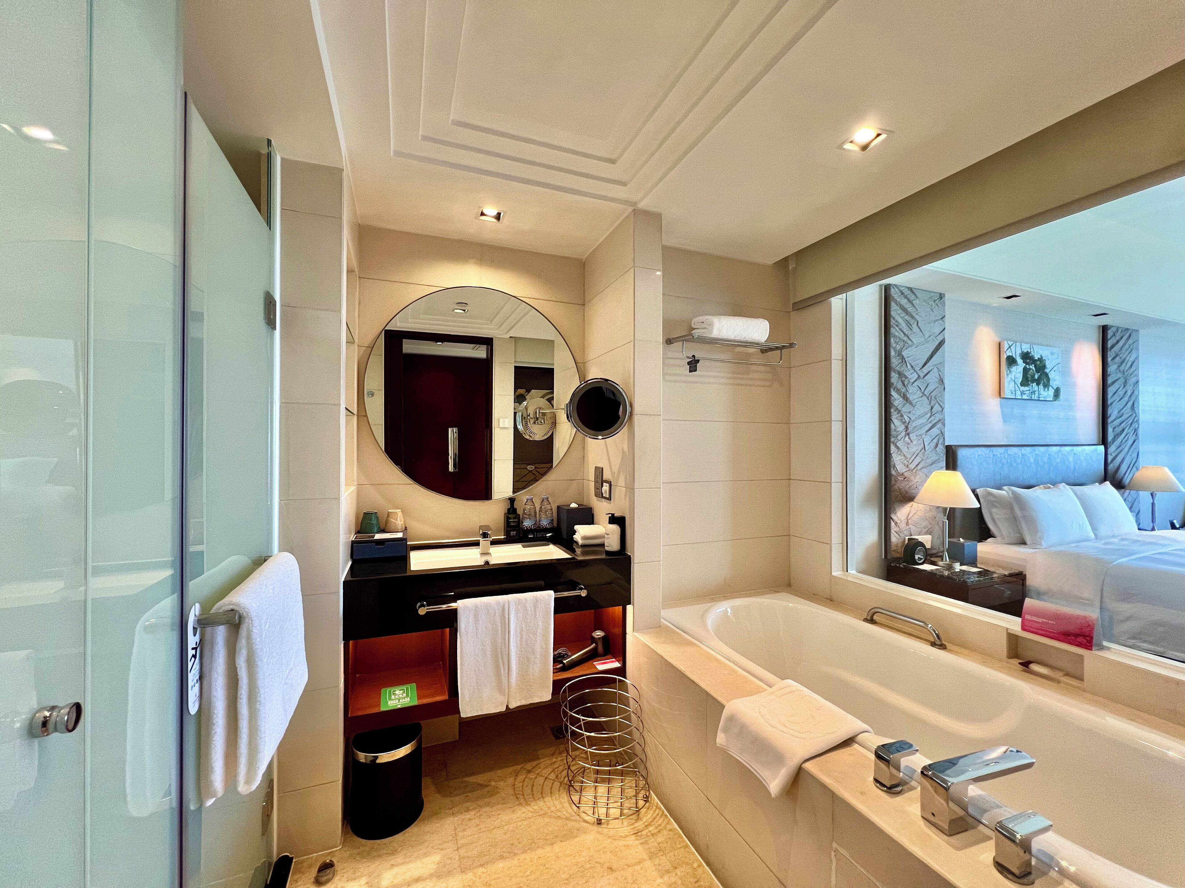 A modern bathroom with a large bathtub, a vanity with a mirror, and a shower area.