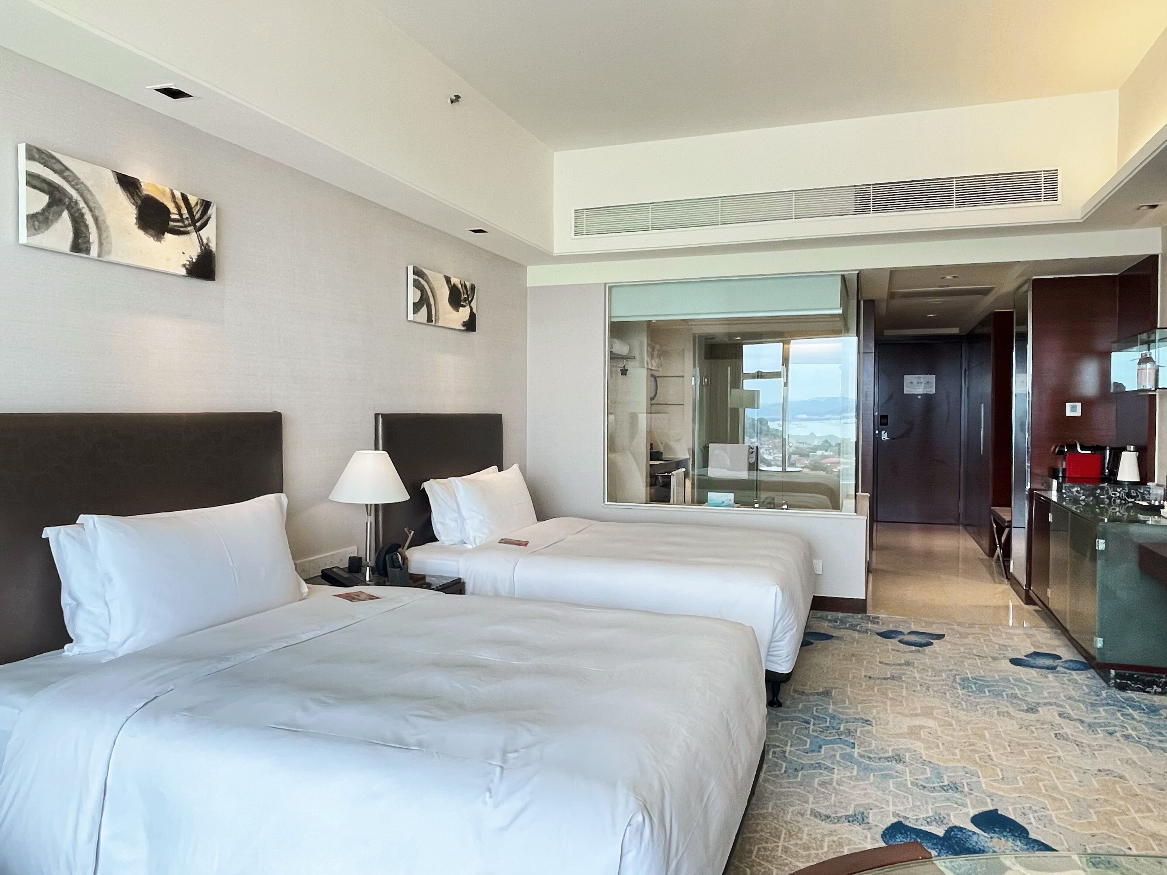 Une chambre d’hôtel avec deux lits, une salle de bain et une vue sur la ville.
