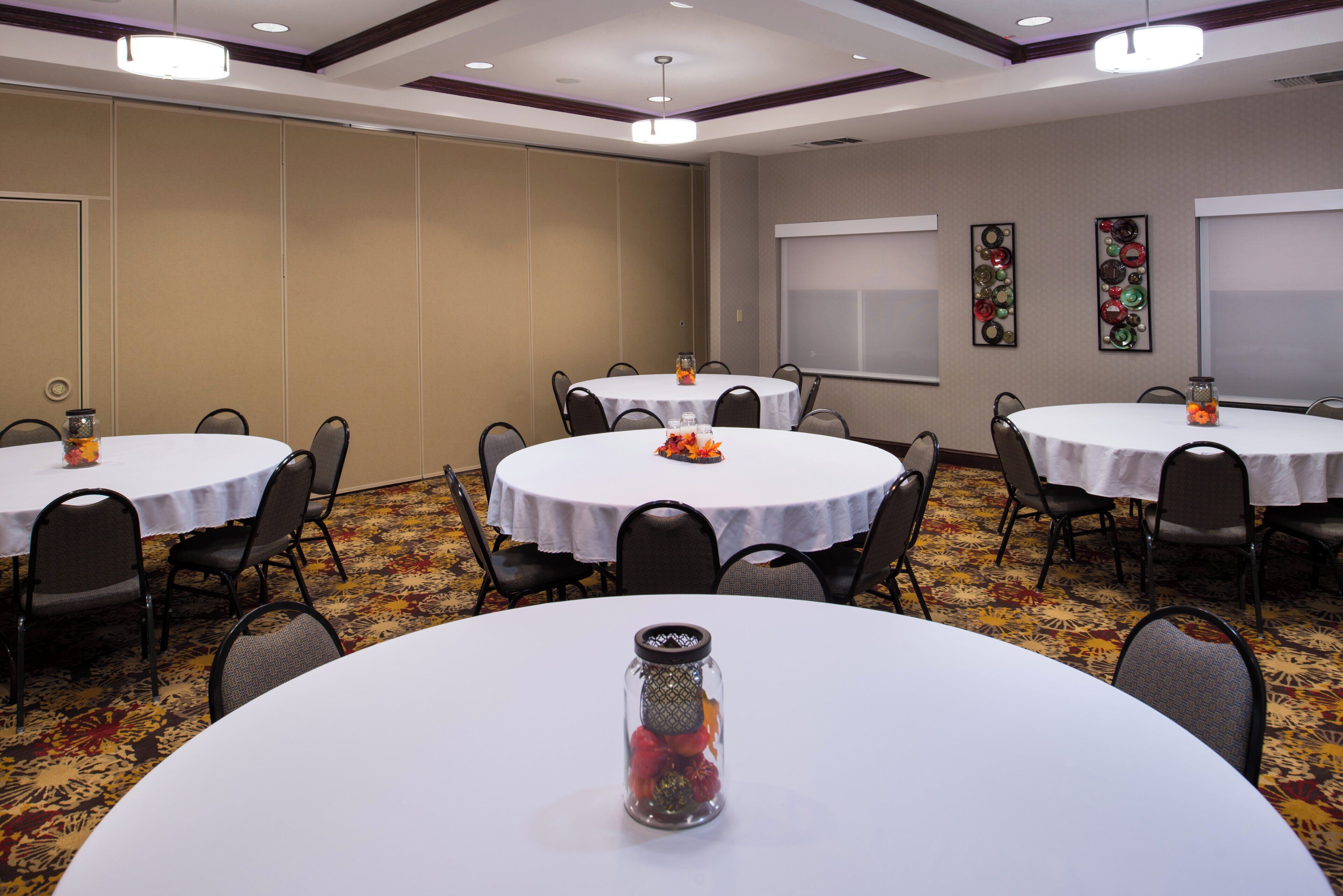 A conference room with round tables, chairs, and decorative items.