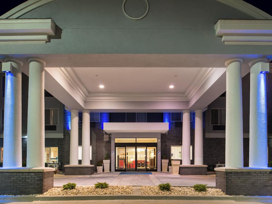 A hotel entrance with a covered patio, columns, and a brick facade.