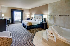 Une chambre d’hôtel comprenant un lit, des tables de chevet, un bureau, une chaise, une salle de bain avec une baignoire et une douche.