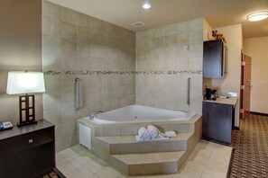 A modern bathroom with a freestanding bathtub, a vanity with a mirror, and a sink. - Holiday Inn Express & Suites Paris, Texas by IHG (Paris)