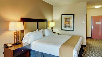 A hotel room with a bed, two bedside lamps, a telephone, and a framed picture on the wall.