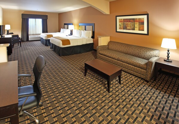 A hotel room with a large bed, a sofa, a desk with a chair, and a TV. - Holiday Inn Express & Suites Paris, Texas by IHG (Paris)