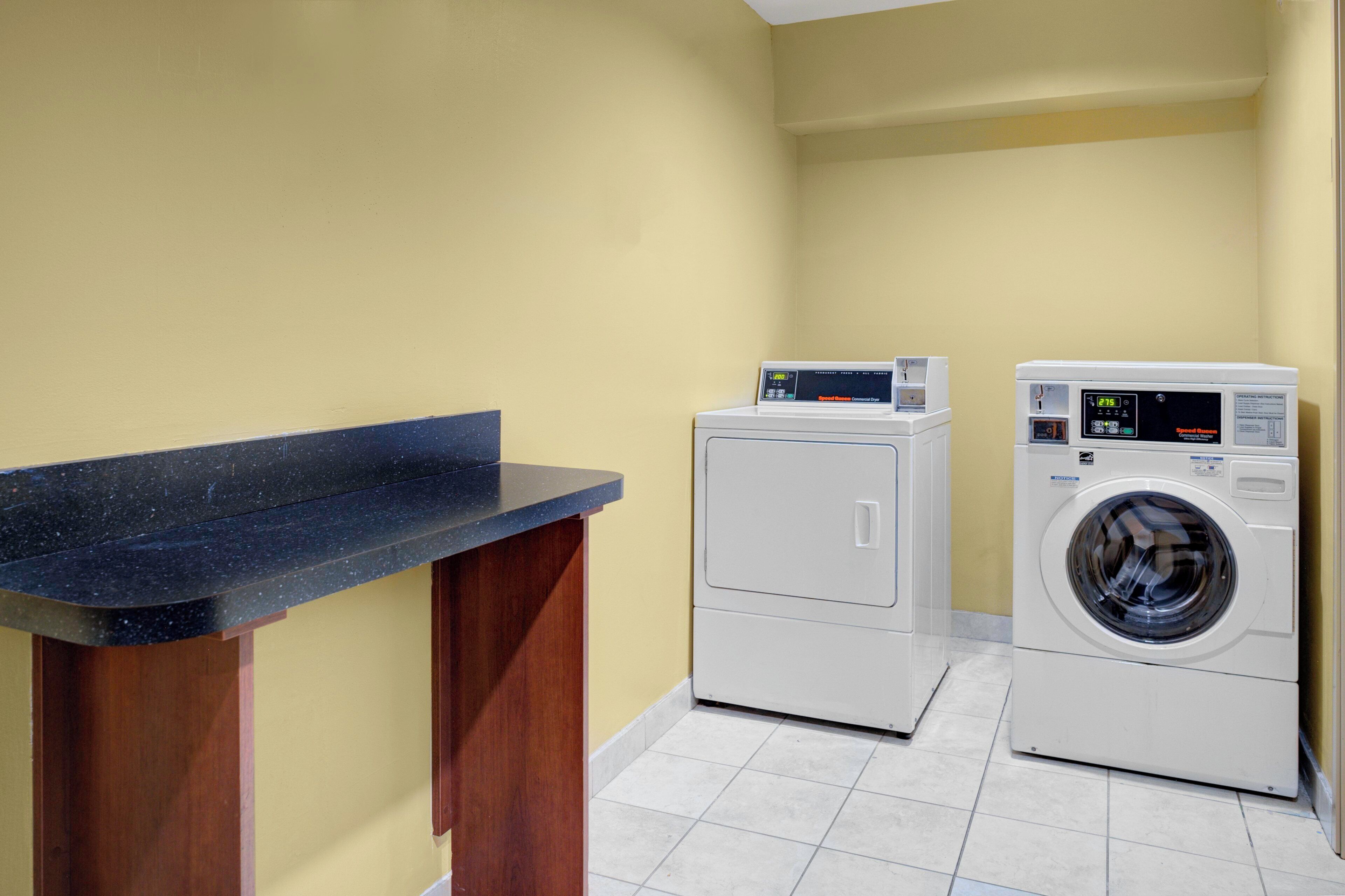 A laundry room with two washing machines and a sink.