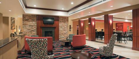 Un hall con chimenea, zona de estar y comedor.