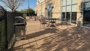 A courtyard with outdoor seating, a building with large windows, and a metal fence. - Holiday Inn Hotel & Suites Lima by IHG (Lima)
