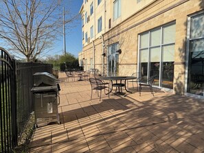 A courtyard with outdoor seating, a building with large windows, and a metal fence. - Holiday Inn Hotel & Suites Lima by IHG (Lima)