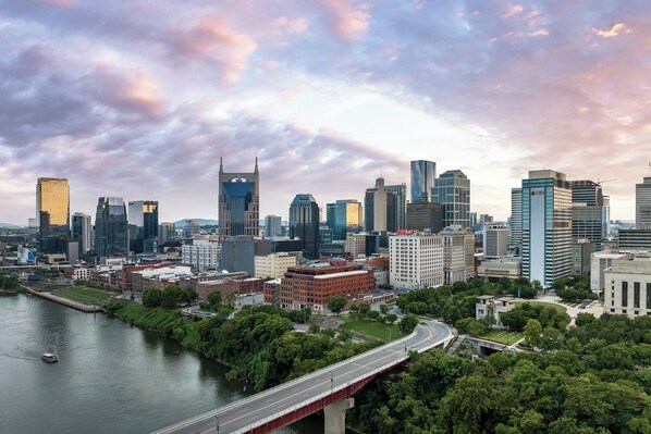 A cityscape with modern buildings, a river, and a bridge.