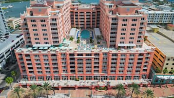 A multi-story hotel with a central courtyard, balconies, and a pool.