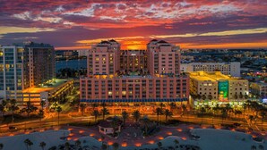 A hotel with a central courtyard, multiple floors, and a view of the sunset over the water. - Hyatt Regency Clearwater Beach Resort and Suites (Clearwater Beach)