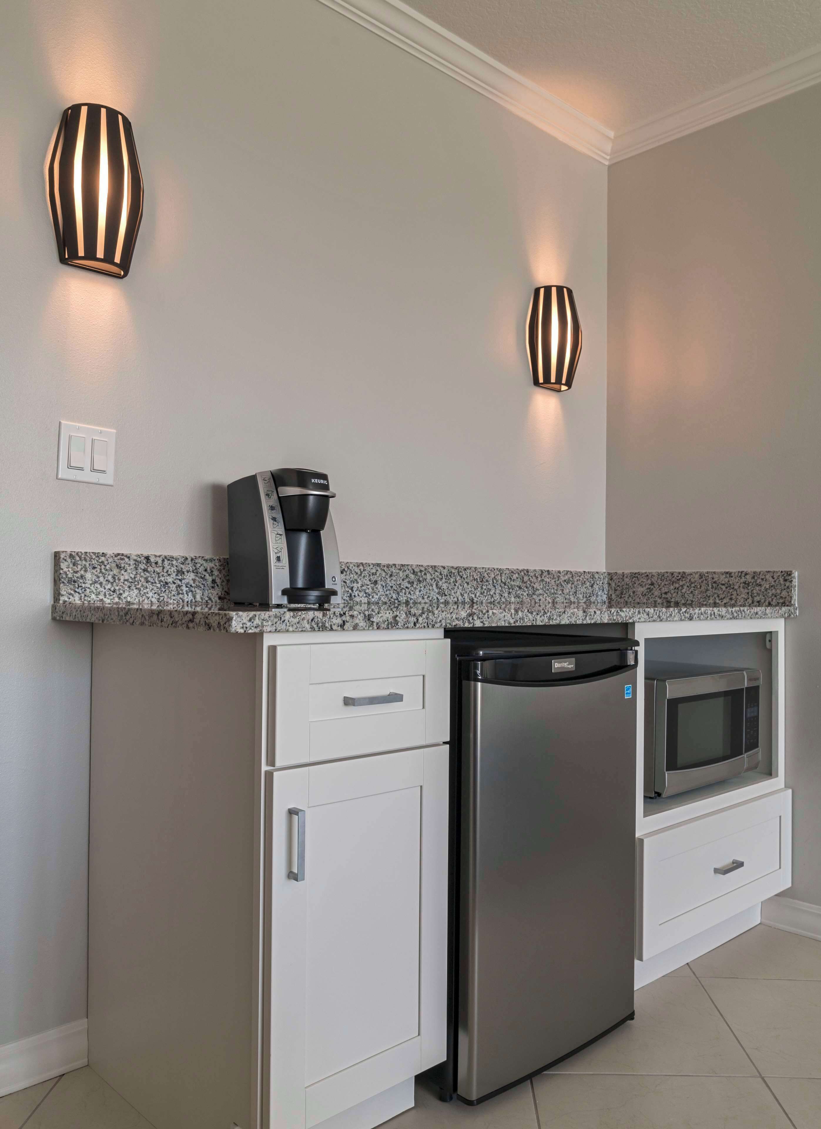 A modern kitchen with a built-in dishwasher, a coffee maker, and a microwave.