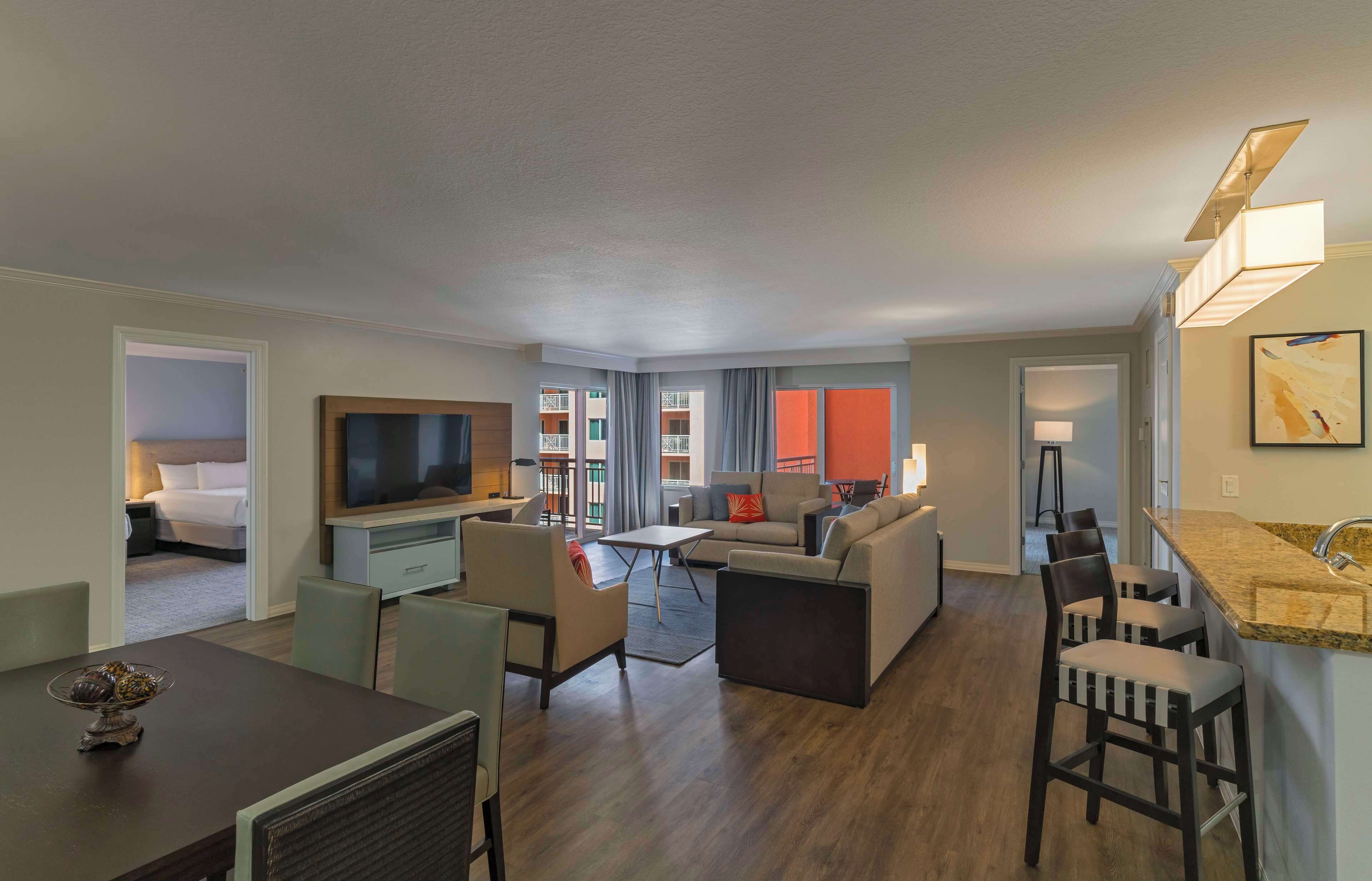 Una habitación de hotel moderna con zona de estar, comedor y kitchenette.