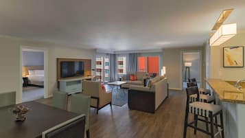 Una habitación de hotel moderna con zona de estar, comedor y kitchenette.