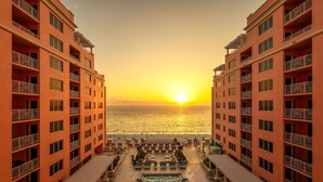 A hotel with a pool, outdoor seating, and a view of the sunset over the ocean. - Hyatt Regency Clearwater Beach Resort and Suites (Clearwater Beach)