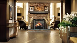 A spacious living area with a stone fireplace, comfortable seating, and a television.