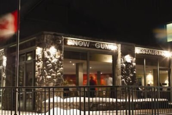 Un restaurante llamado "Snow Gum" con fachada de piedra y una valla metálica en la entrada.