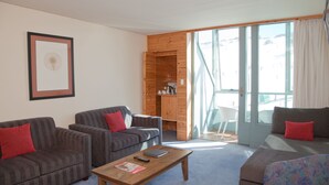 A modern living room with two sofas, a coffee table, and a wooden cabinet.