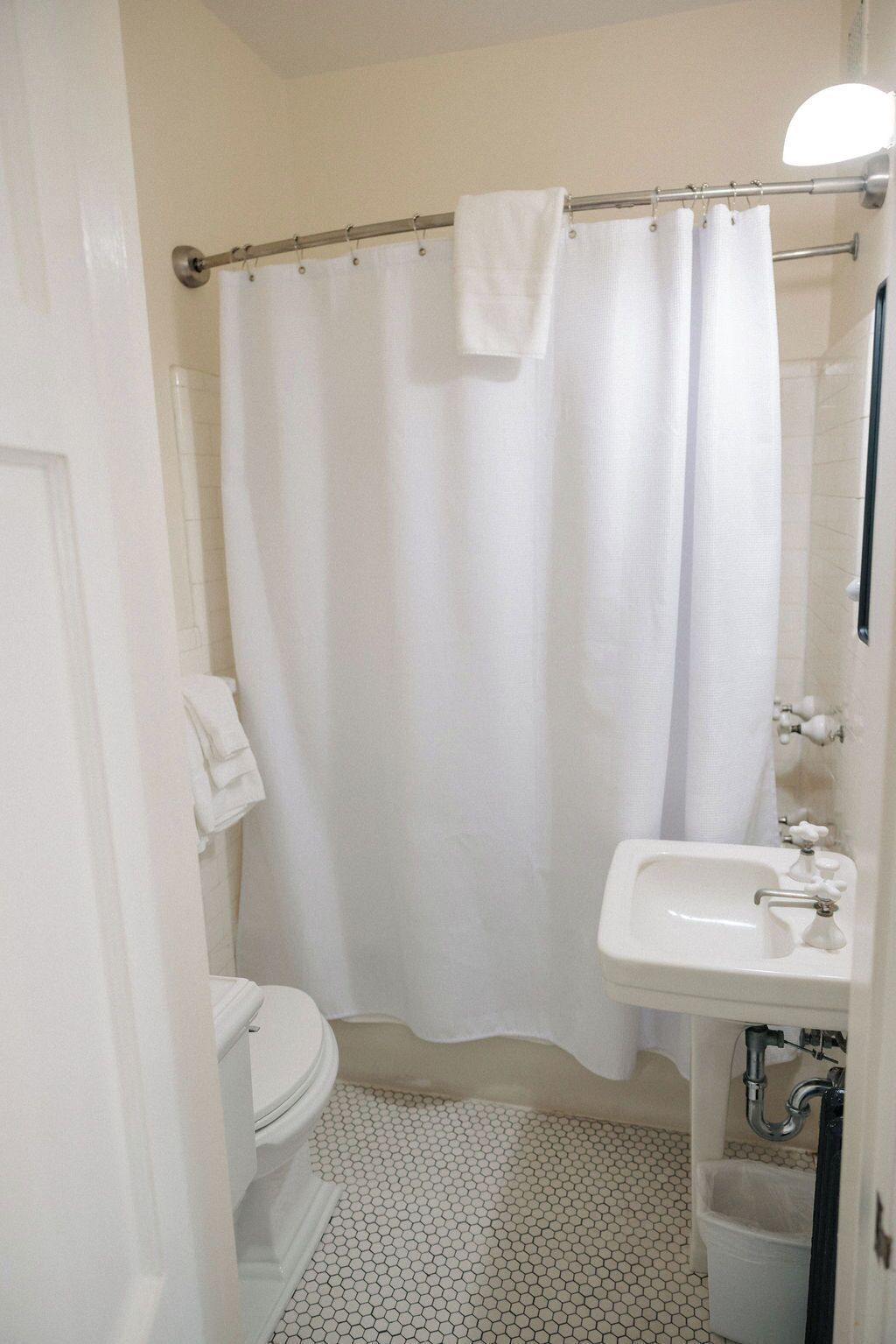 Une salle de bain équipée de toilettes, d’un lavabo et d’un rideau de douche.