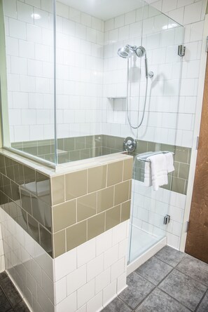 A modern bathroom with a glass-enclosed shower, beige and white tiles, and a glass partition. - Hotel Indigo Athens University Area by IHG (Athens)