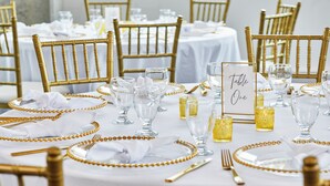 A table set with gold bead accents, clear glassware, and a 'Table One' sign. - Hotel Indigo Athens University Area by IHG (Athens)