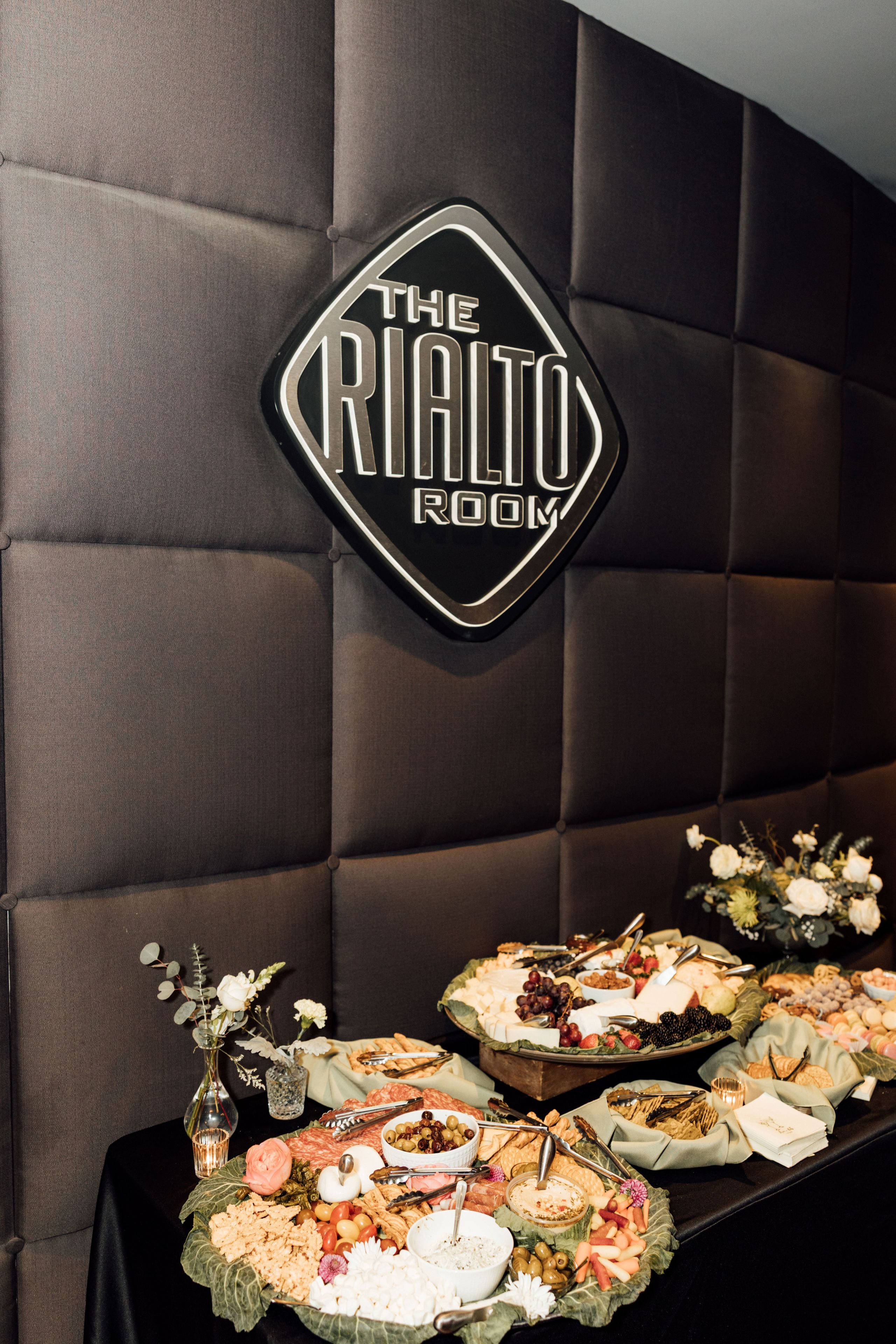 A room with a sign reading 'The Rialto Room' and a buffet table with various food items.