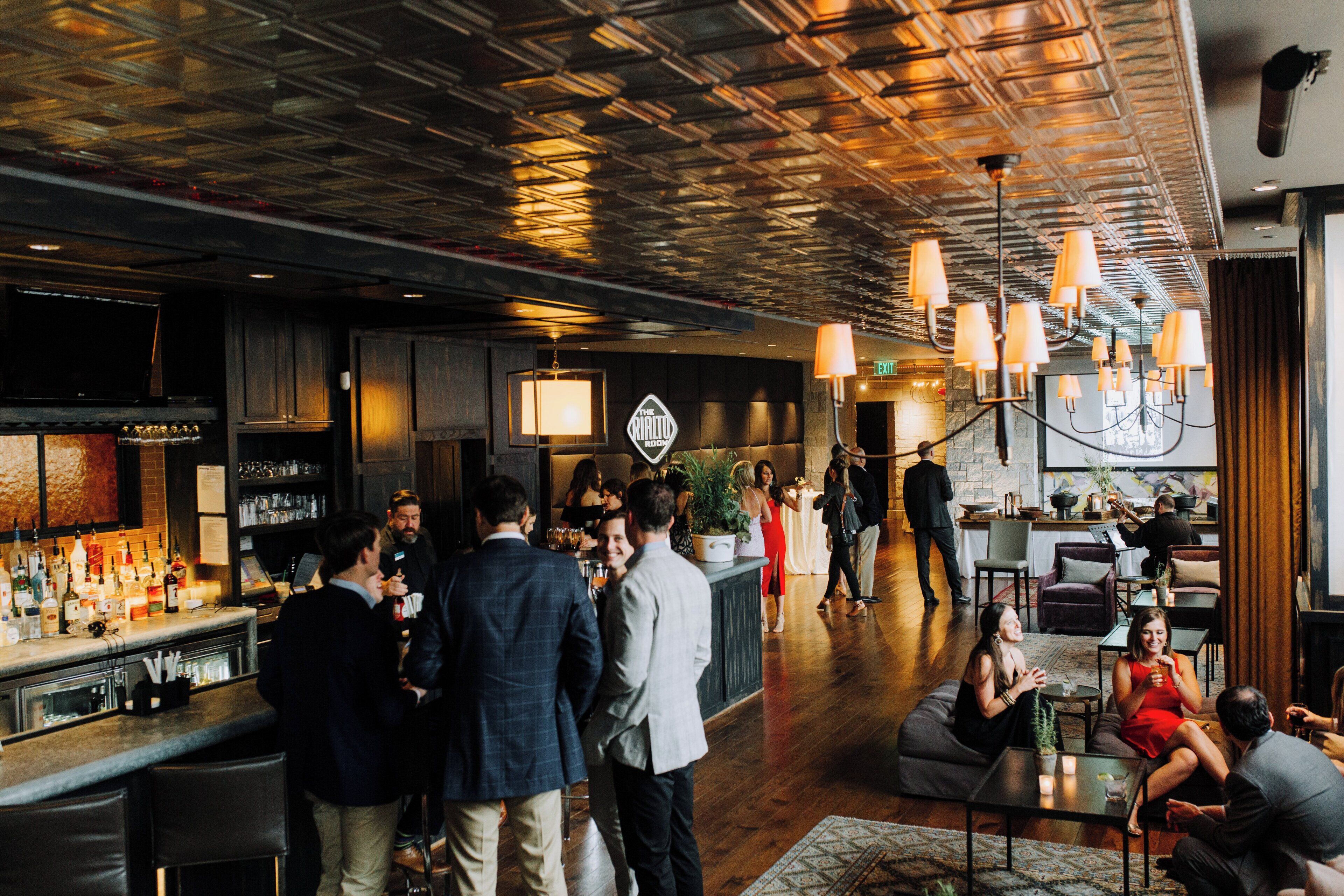 A bar area with a counter, seating, and a sign indicating 'The Grill Room'.