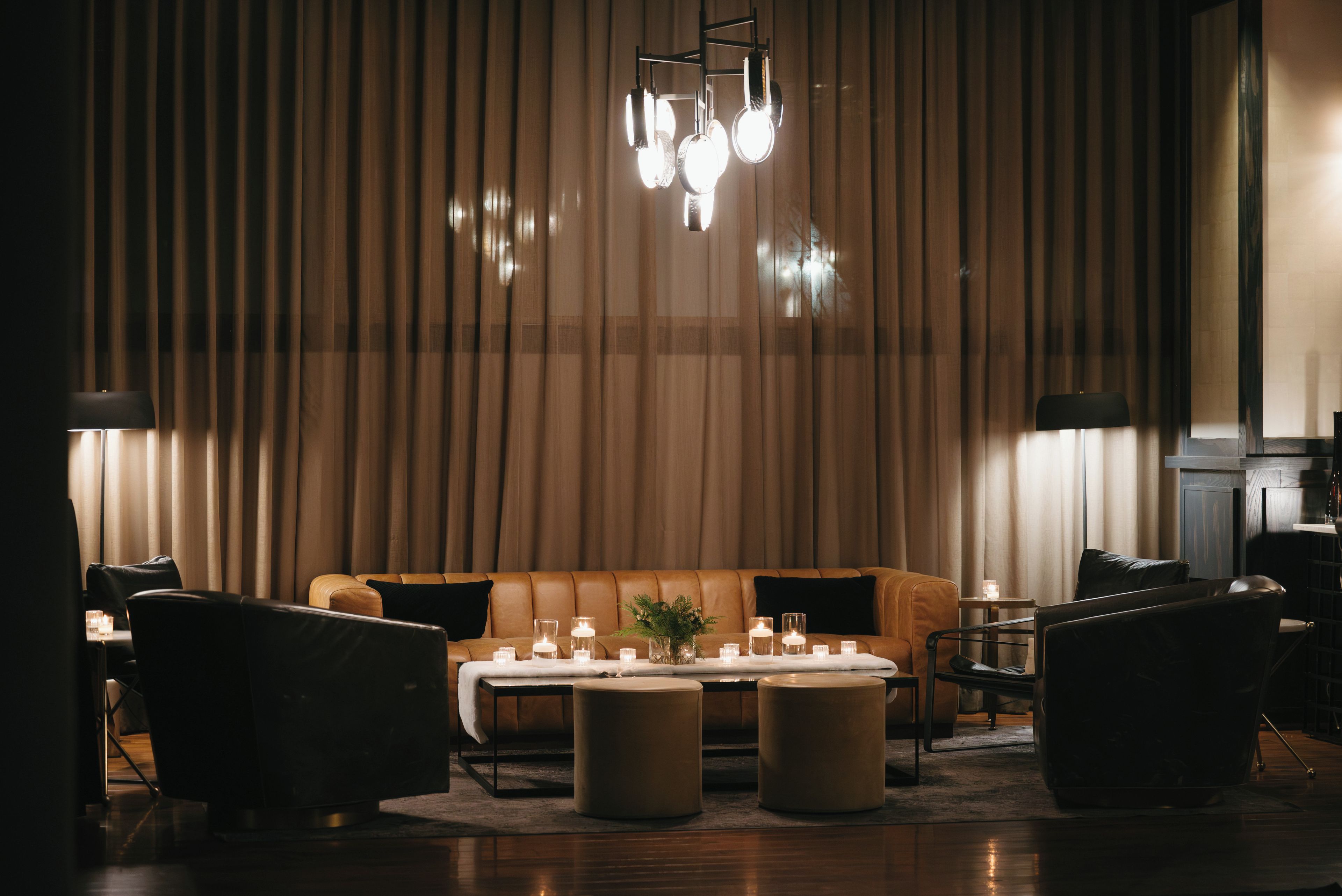 A modern interior with a leather sofa, round coffee table, and chairs.