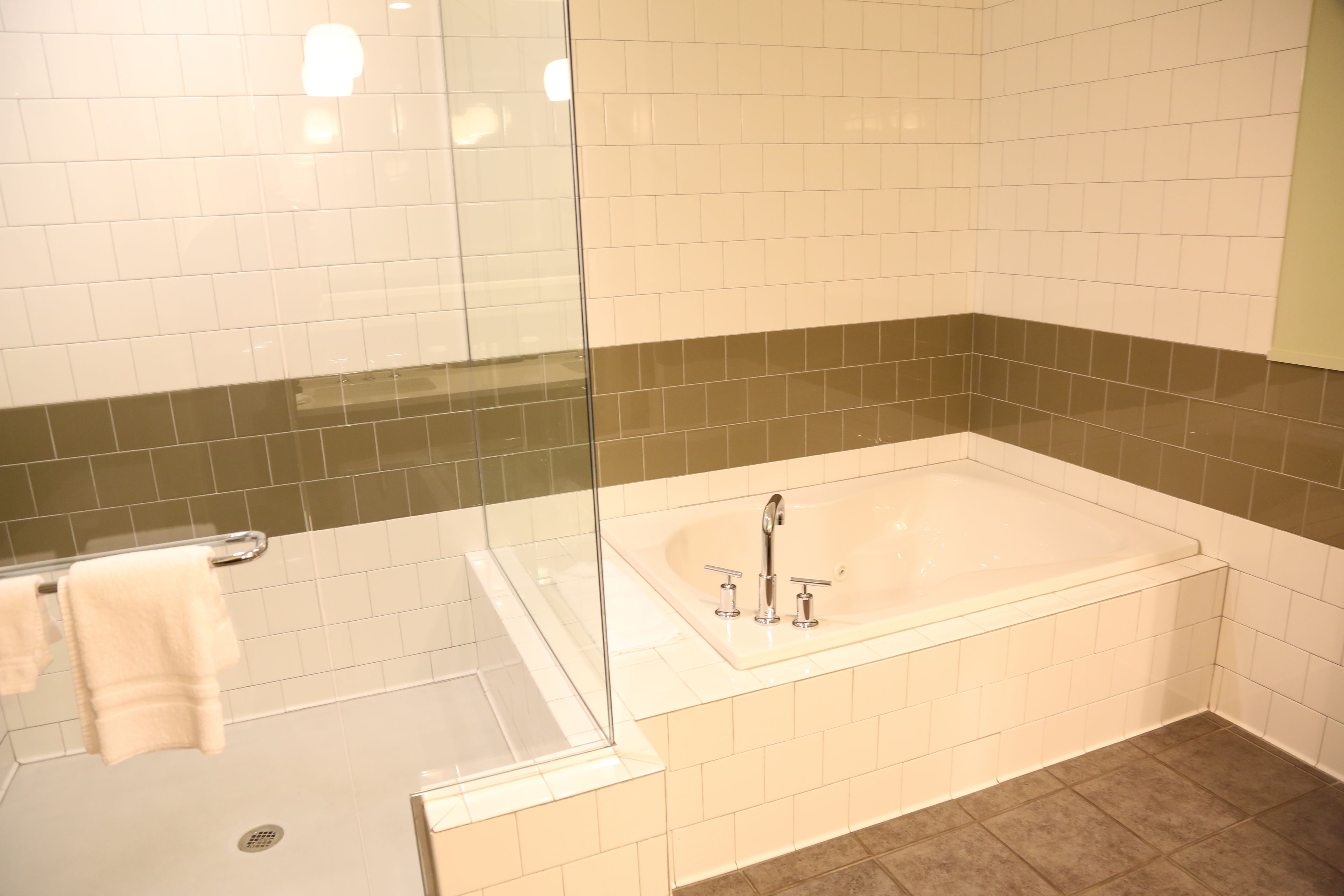 A modern bathroom with a glass-enclosed shower, a freestanding bathtub, and a tiled floor.