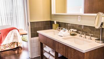 Une salle de bain avec un double lavabo, un miroir et un porte-serviettes.