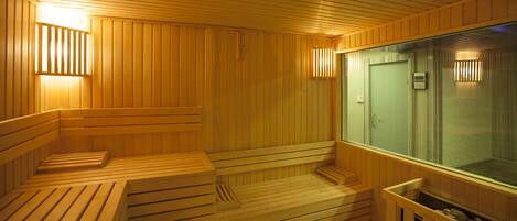 A sauna with wooden benches and a glass door.