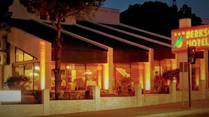 The exterior of the Berksoy Hotel at night, featuring a modern architectural design with a prominent neon sign, large windows, and a well-lit entrance area. - Berksoy Hotel (Bergama)