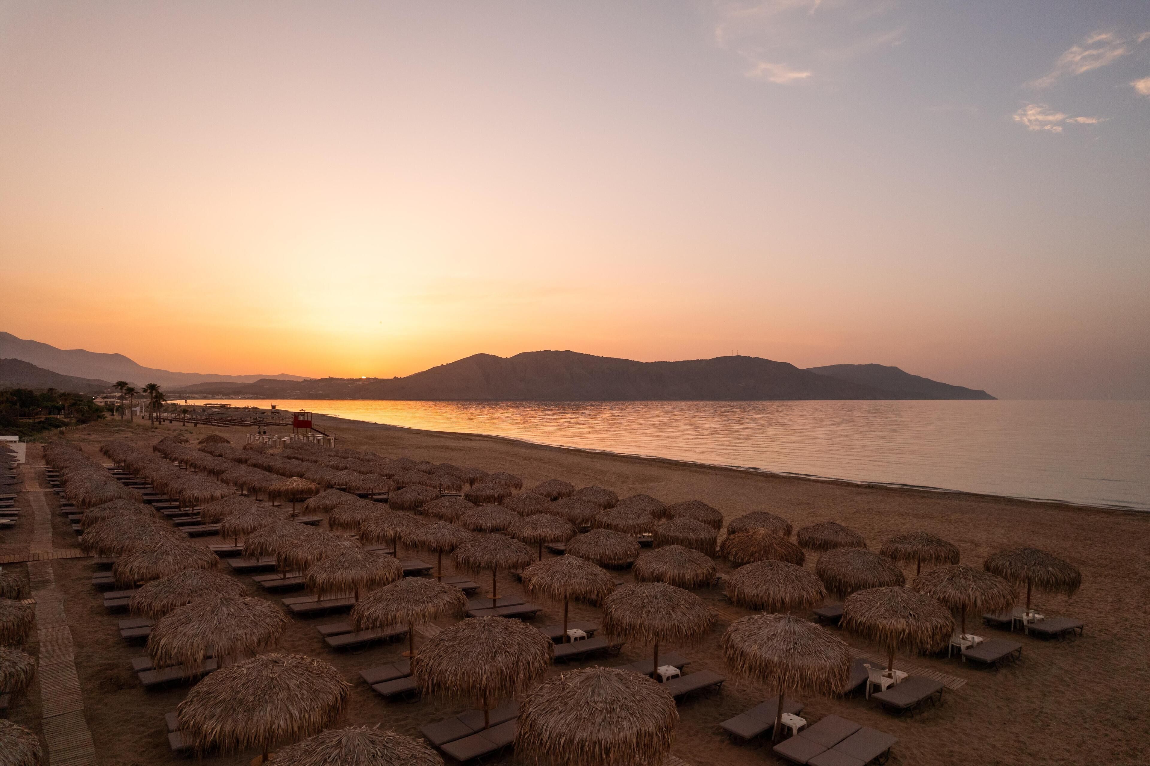 På stranden, solsenger, strandhåndklær og sandvolleyball