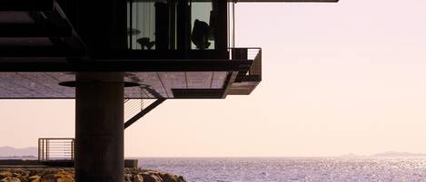 A pier extending into the water with a balcony overlooking the sea.