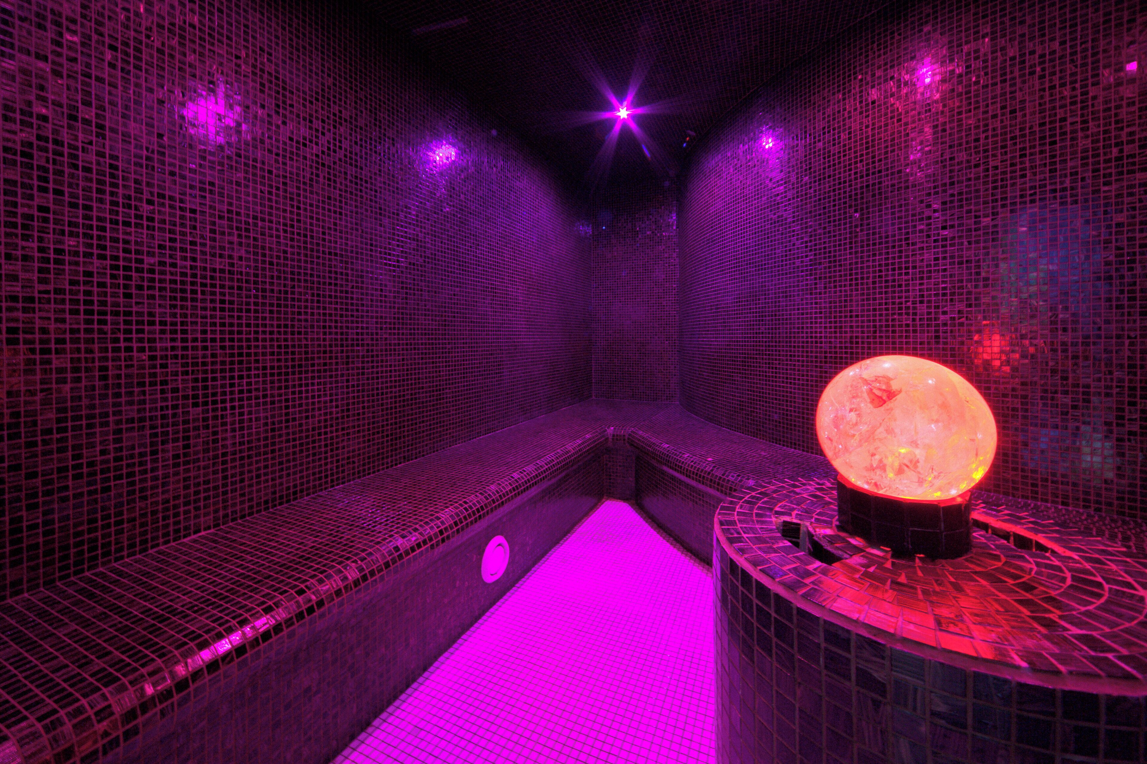 A spa room with a seating area and a central feature that appears to be a heated stone or lamp.