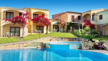 Una piscina al aire libre de temporada, sillones reclinables de piscina