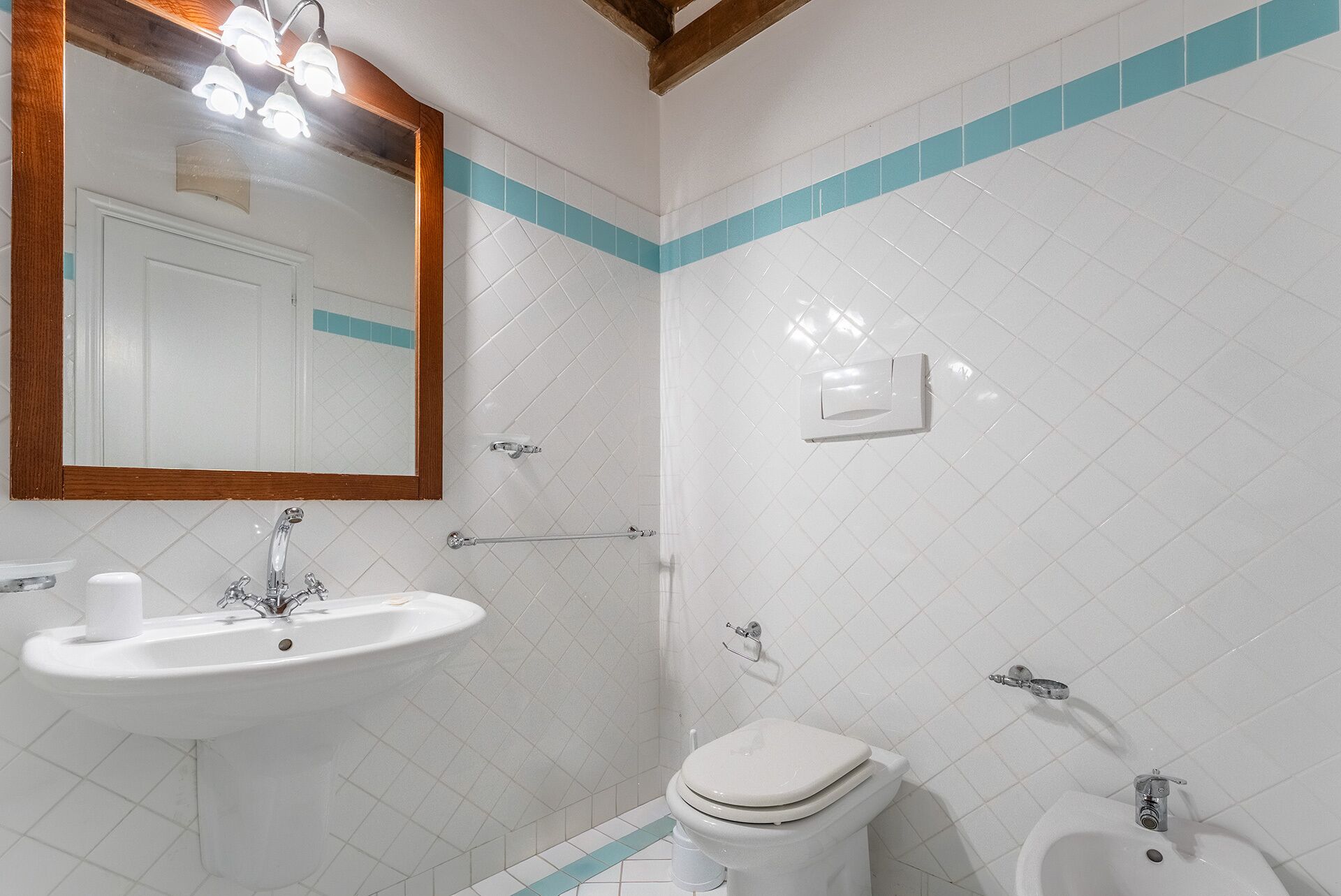 Une salle de bain équipée d’un lavabo, de toilettes, d’un bidet et d’un miroir.