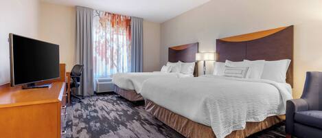 A hotel room with two beds, a TV, a desk, and a chair.