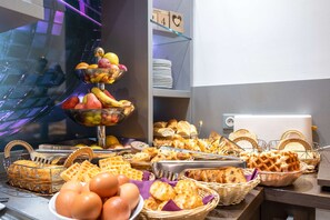 A buffet with various food items including fruits, waffles, and pastries. - Comfort Hotel Orleans Olivet (Olivet)