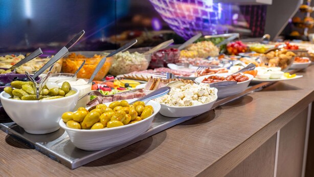 A buffet with various food items and utensils. - Comfort Hotel Orleans Olivet (Olivet)