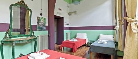 A hotel room with two beds, a mirror, a radiator, and a green ceiling.